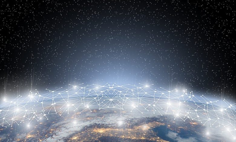 Aerial image of a city at night with a graphic representation of a network above it.