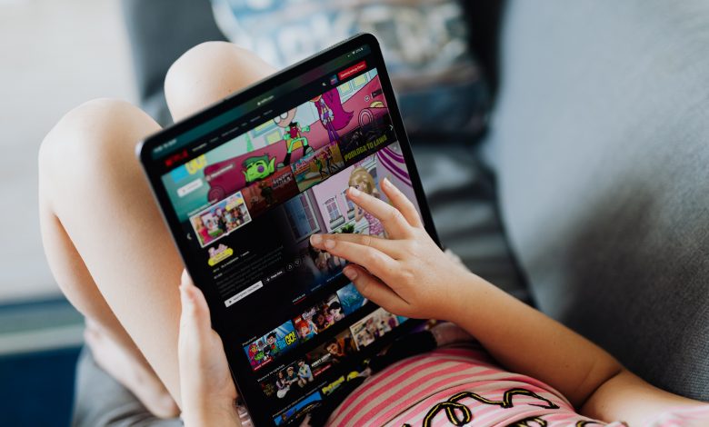 A person accessing Netflix on a tablet