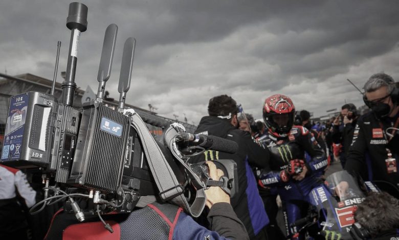 Man carrying camera and facing Yamaha Grand Prix team