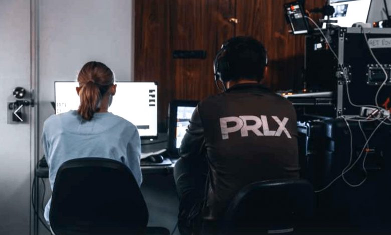 Two people sitting with their backs facing the camera. One of them is wearing a jacket PRLX.